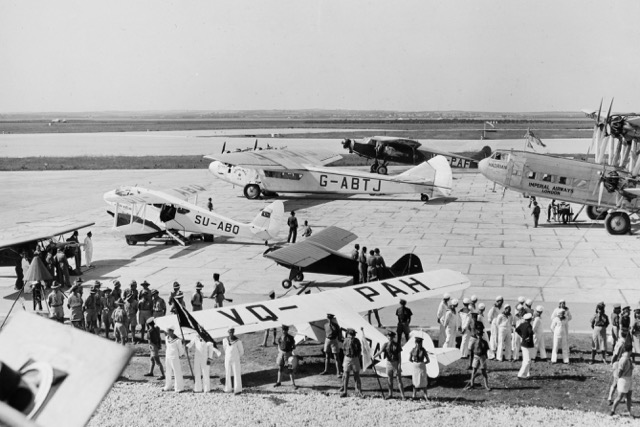 Graduation of the first class of the Palestine Flying Service at Lydda Airport in April 1939. Aircraft include VQ-PAH, a Taylorcraft BC used as a trainer by the school; SU-ABQ, a de Havilland Dragon Rapide of Egypt's Misrair; G-ABTJ 'Artemis, an Imperial Airways Armstrong Whitworth Atalanta class, serving the Middle East, Africa, and the Far East; a Handley Page H.P.42 Hannibal class (G-AAUE 'Hadrian') of Imperial Airways, flown on routes as far as India; and VQ-PAF, a tri-motor Fokker F.XVIII tri-motor of Hevra Avirit Miskharit. The two aircraft in front of VQ-PAH with graduating pilots are Taylorcrafts VQ-PAI and VQ-PAJ. In the foreground are members of several Jewish organizations. (Israel Government Press Office) 