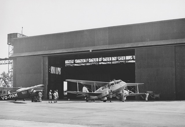 De Havilland D.H.89A Dragon Rapide VQ-PAR at Lydda Airport, 25 October 1947. This was the main aircraft of Aviron (Palestine Aviation Co Ltd), the first passenger airline owned by Jewish interests resident in the Holy Land, with secret ties to the Haganah Jewish defense forces. Behind the aircraft is the original hangar still in use by El Al for some of its Boeing jet aircraft. To the left is a Polish-built RWD 13 (VQ-PAM) of Aviron. (Israel Government Press Office) 