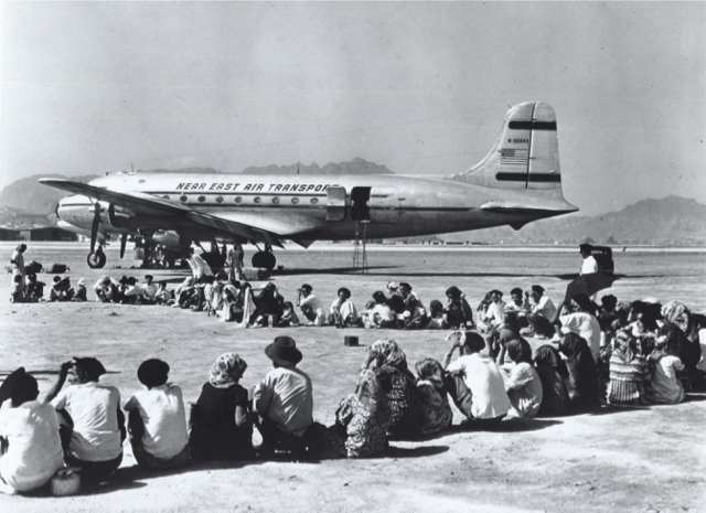 A Douglas DC-4 of Near East Air Transport, the early affiliate of EL AL used in immigrant airlifts, picking up Yemenite Jews in November 1949 in Aden (then a British Protectorate), at the southern tip of the Arabian Peninsula, to bring them to safety and a new home in Israel. Although in Near East markings, this aircraft is painted in an Alaska Airlines color scheme. Alaska Airlines, through its adventurous President James Wooten, was the original supplier of aircraft for the Yemenite airlift. (Central Zionist Archives, Jerusalem)
