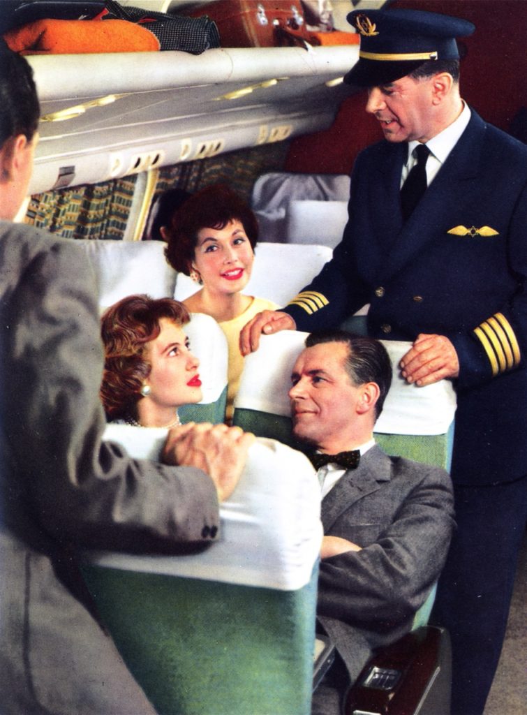 The captain of an EL AL flight converses with passengers in the coach section of a Britannia, 1958 (MG, from an EL AL brochure)