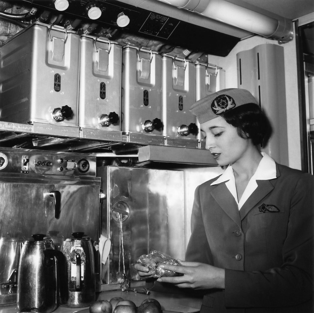 Aliza Fleisher, one of EL AL's early stewardesses, preparing a fruit snack in the galley of a Britannia, about December 1957. (EL AL Archive)