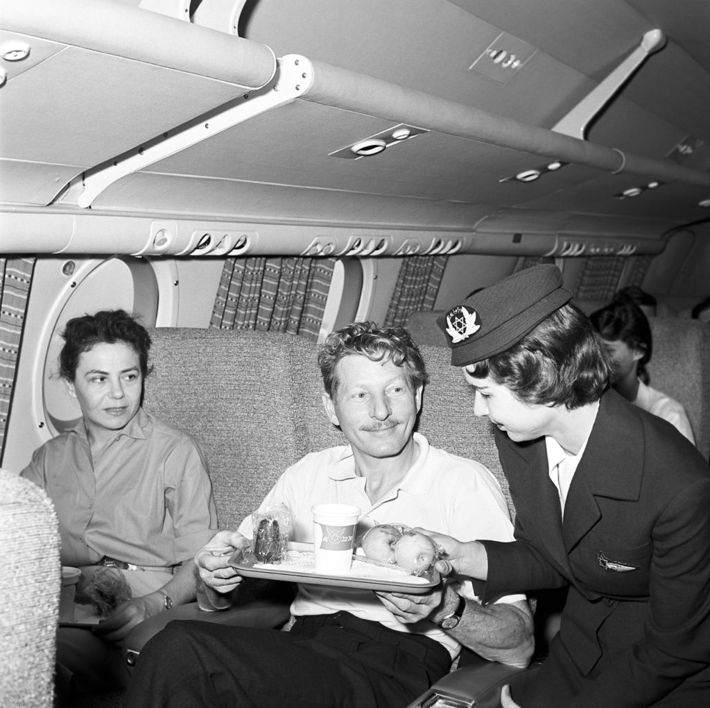 International entertainer Danny Kaye and his songwriter wife Sylvia Fine, frequent fliers with EL AL, enjoying friendly in-flight service, about 1958. (EL AL Archive)