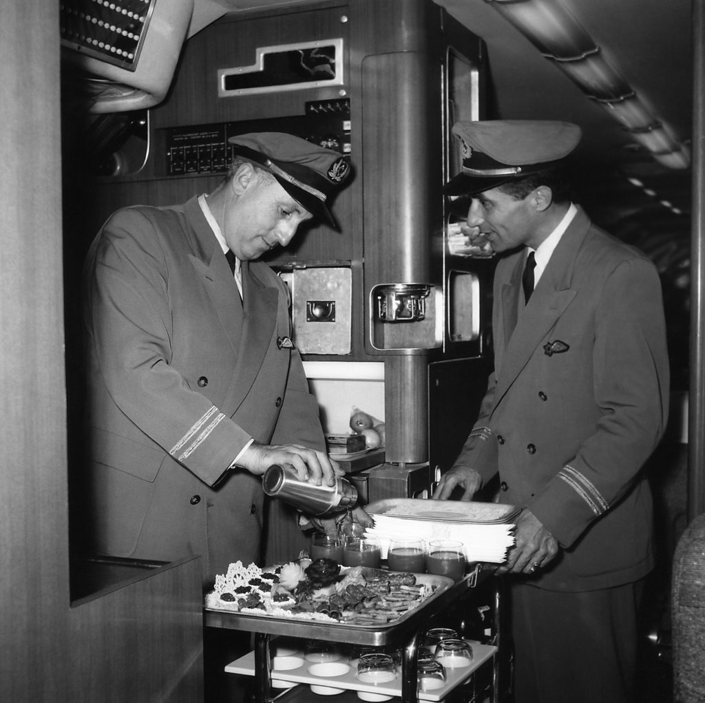 Stewards Werner Wolf and Fabio-Teo Levi (right) arrange dessert service in the galley of a Britannia, December 1957. The usual cabin attendant complement was three or four. (EL AL Archive)