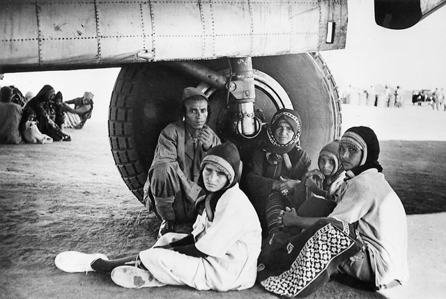 Yemenite Jews taking shelter in the shade at the wheel of an Avro Tudor 1 aircraft at the hot, dusty airfield in Aden, November 1949. The Yemenites had never seen an airplane before, and they sat in awe and nervous anticipation, awaiting the fulfillment of the biblical prophecy that they would be returned to the land of their forefathers "on the wings of eagles". (Central Zionist Archives, Jerusalem) 